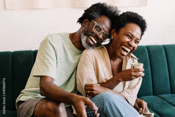 Obraz Happy couple having fun watching tv together at home