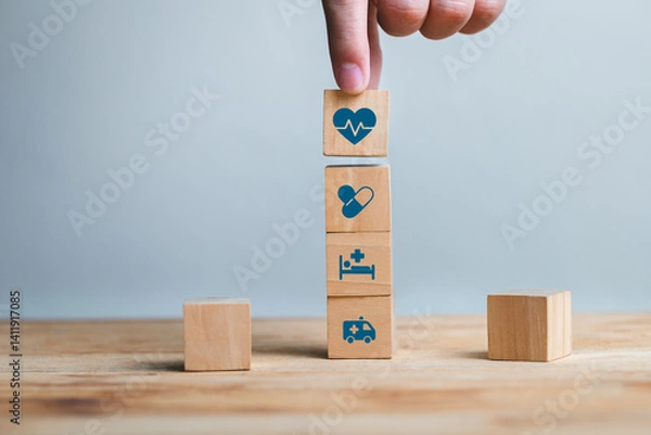 Fototapeta Hand Stacking Wooden Blocks with Health Icons on a Table