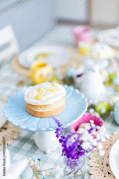 Obraz Easter table set up with lemon cake on blue platter