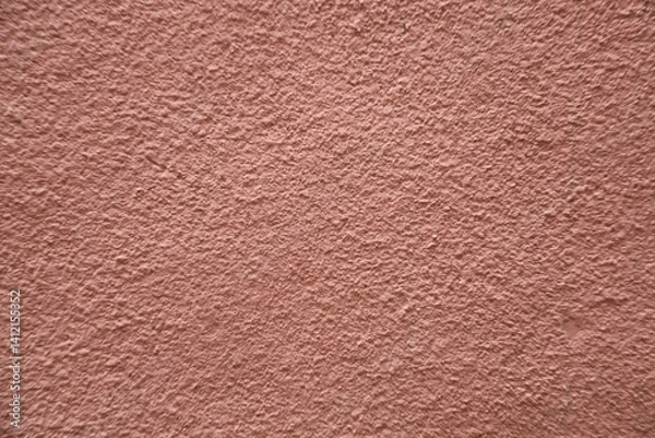 Fototapeta red pink plaster wall texture. Seamless surface abstract solid background Pale painted wall built structure textured stucco in terracotta color. seamless texture of plaster backdrop pattern Peach Fuzz