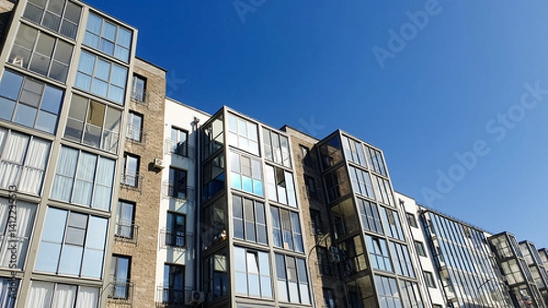 Obraz Residential neighborhood, apartment building with balconies and windows. Residential building in nature in the city.