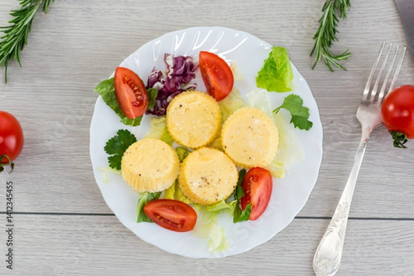 Obraz Round omelette with tomatoes and fresh lettuce on a served table