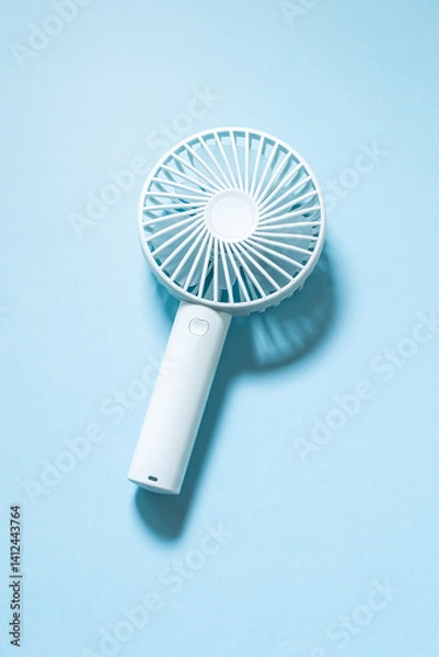 Fototapeta ハンディファン　携帯扇風機　水色背景