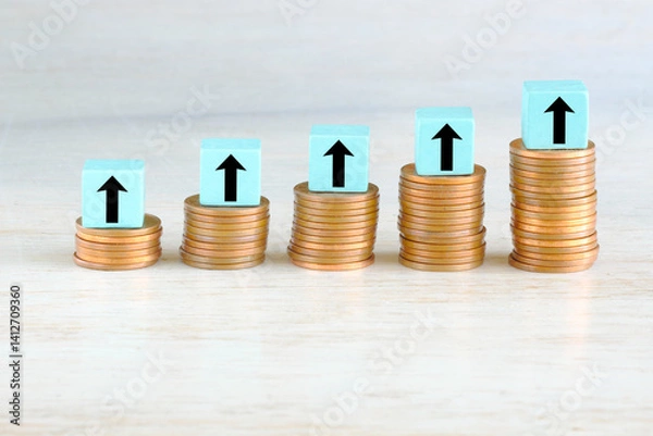 Obraz Business concept for financial growth, interest rate increase, inflation, high price, tax and tariffs rise . Arrow up sign on wooden cube blocks above stack of coins, free  copy space