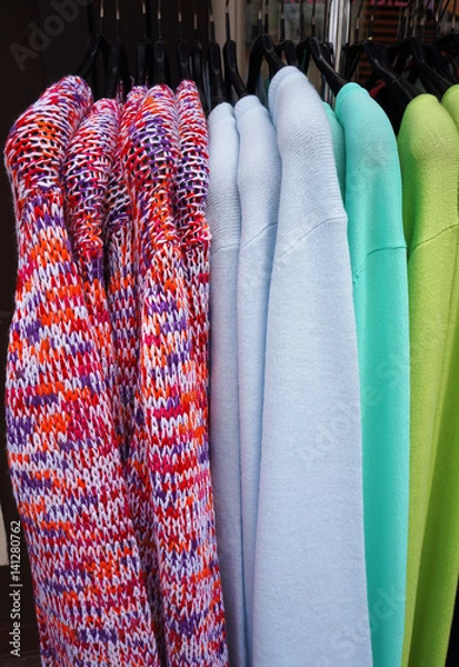 Fototapeta Pullovers on hangers.