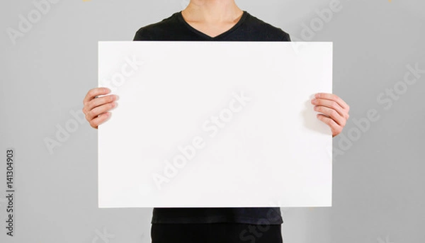 Fototapeta Man showing blank white big A2 paper. Leaflet presentation. Pamphlet hold hands. Man show clear offset paper. Sheet template. Booklet design sheet display read first person.