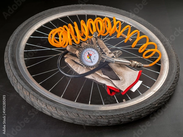 Obraz Inflating a bicycle wheel with a compressor.