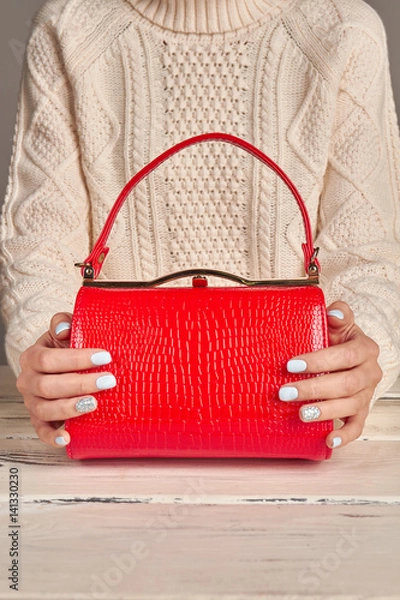 Obraz Elegant red lady's handbag in female hands.