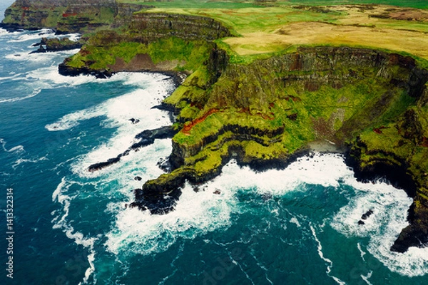 Obraz Dramatic Aerial of Giant’s Causeway Cliffs With Crashing Blue Waves During a Cloudy Day