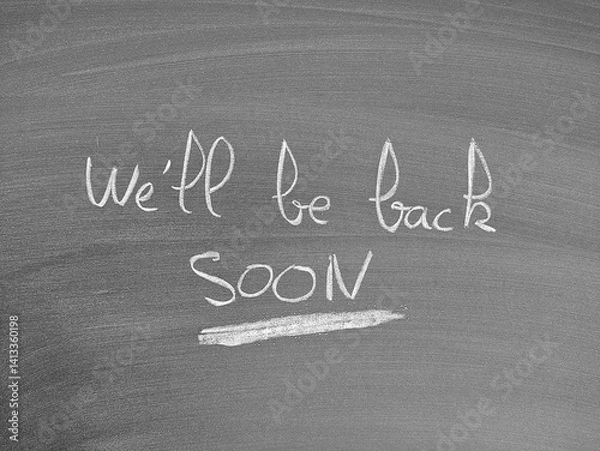 Fototapeta A chalkboard message states, "We'll be back SOON", hinting at temporary closure or interruption with a promise of return.
