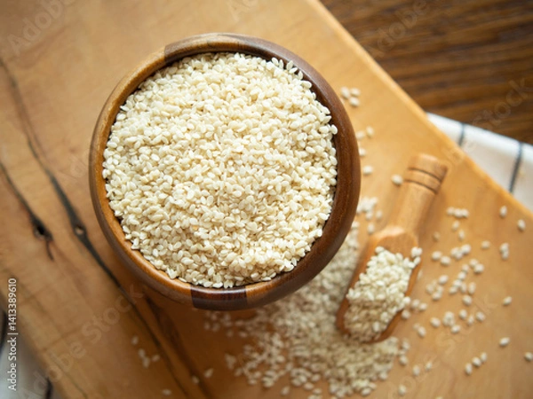Fototapeta Bowl with sesame seeds and wooden spatula on rustic background