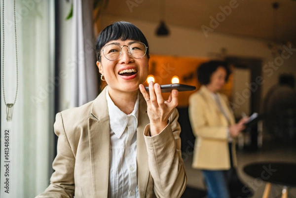 Obraz Japanese businesswoman use mobile phone for sent voice message on work