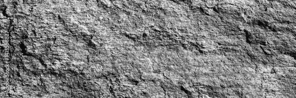 Obraz A close up of a rough, cracked rock surface with earthy gray. The natural texture and weathered details make it ideal for backgrounds, geology themes, and organic material references.