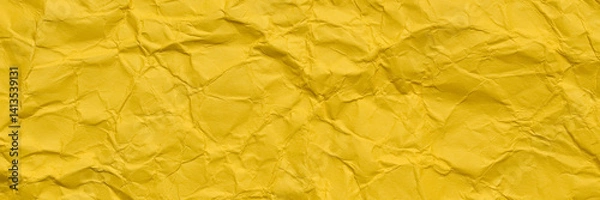 Fototapeta A textured yellow crumpled paper background with natural creases and folds. Ideal for design projects, digital graphics, or creative presentations requiring a vibrant, Long banner