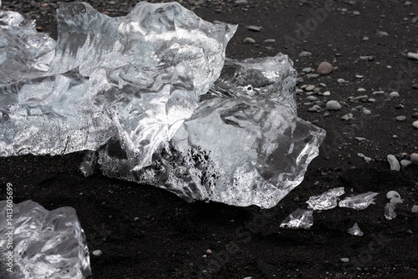 Fototapeta close-up of glacier ice on a black sand beach in Iceland melting in the sand