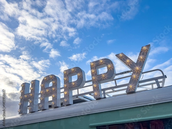 Fototapeta Lighting happy text on a roof with sky background copy space.