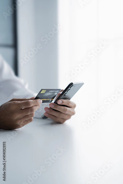 Obraz Asian male hold credit card and use mobile phone for online transactions.