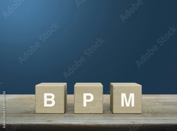 Obraz BPM acronym on wood block cubes on wooden table over light blue wall, Business process management concept