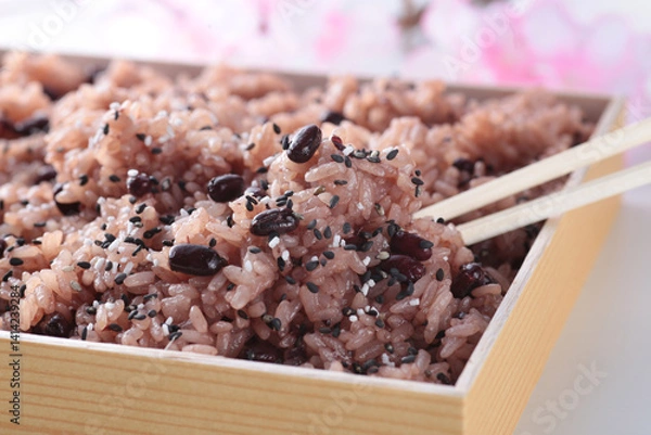 Fototapeta 日本でお祝いの行事の時に食べるピンクの背景で桜を入れて撮影したお赤飯