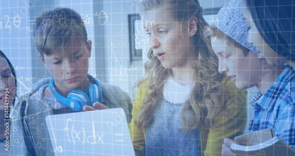 Fototapeta Image of mathematical equations over school children using laptop in classroom