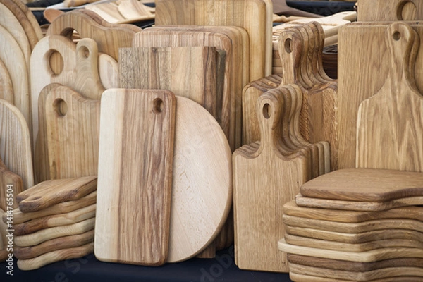 Obraz Handcrafted wooden cutting boards in various shapes and sizes are displayed at local artisan market
