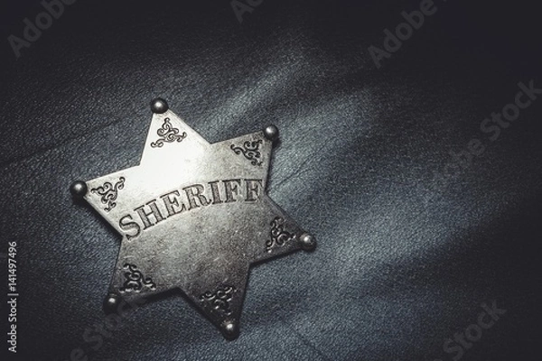 Obraz Sheriff badge on gray leather texture background. Macro shot.