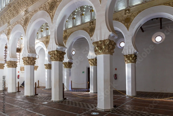 Fototapeta Synagogue of Santa Maria la Blanca (Ibn Shoshan Synagogue), Toledo, Spain, prayer hall with white pillars and arcades with golden floral capitals, Almohad architecture.
