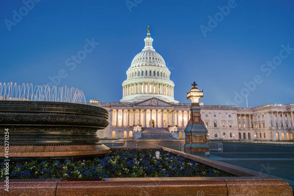 Fototapeta The illuminated U.S. Capitol Building in Washington D.C. at dawn with a small fountain