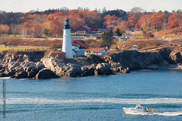Obraz Portland Head Light in Cape Elizabeth, Maine as seen from the Atlantic Ocean on an autumn morning with trees in fall colors. An historic 1791 lighthouse still in operation.