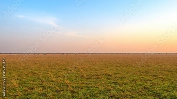 Fototapeta Serene Sunset Over Expansive Grassland with Herd of Wildlife