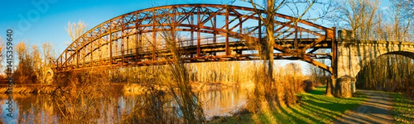 Obraz Winter landscape with an old railway bridge and reflections on a sunny evening near Landau an der Isar, Dingolfing-Landau, Bavaria, Germany