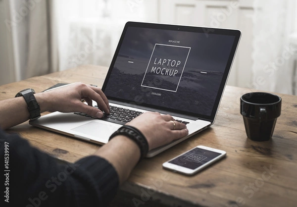 Fototapeta User with Smartphone and Laptop on Desk