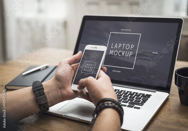 Fototapeta User with Smartphone and Laptop on Desk Mockup 2