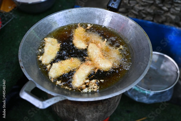 Fototapeta Fried bananas in hot oil in a pan