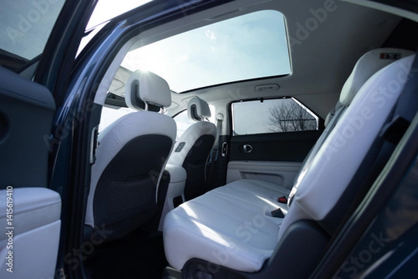 Fototapeta Panoramic glass sun roof in the modern electric car. Clean sunroof and view at the sky from the inside or car interior. The view from the empty car with rear seats