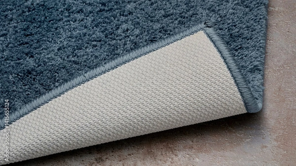 Fototapeta Soft blue rug showing textured surface and backing on a neutral floor.
