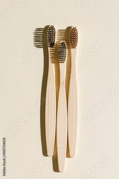 Obraz Eco friendly Bamboo toothbrushes with white bristles at sunlight with dark shadows on beige background. Sustainable living concepts, minimal style aesthetic photo, top view set wooden brushes