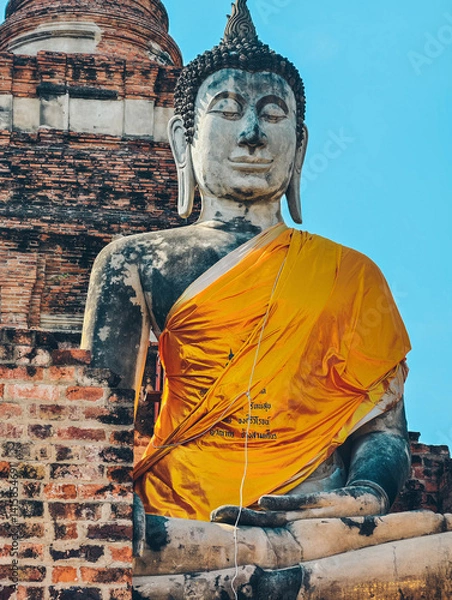 Obraz Close-up view of large Buddha statue draped in yellow robes in Ayutthaya, Thailand. 