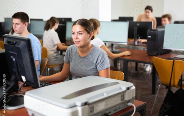 Fototapeta Portrait of young female student studying in university computer class