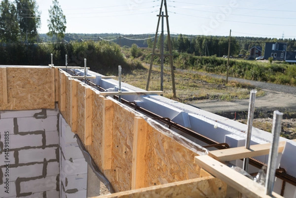 Obraz Construction Site Detail: Close-up of Wooden Formwork and Rebar for Concrete Foundation with Rural Landscape