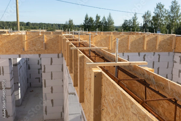 Obraz Construction Site in Rural Setting: Wooden Formwork and Rebar for Concrete Foundation with Natural Background