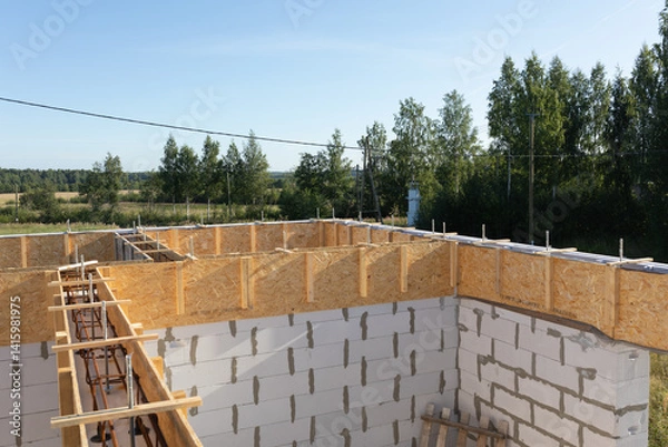 Obraz Construction Progress: Wooden Formwork and Rebar for Concrete Foundation with Rural Landscape Background
