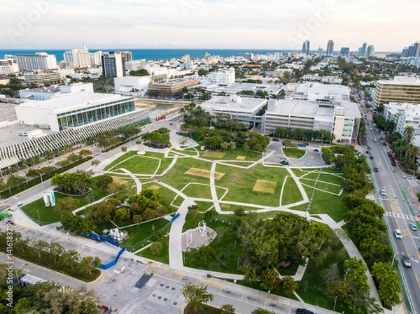 Fototapeta Miami Beach, Florida - Feb 19, 2025: Aerial view of Pride Park near the Miami Beach Convention Center, with open green space, art installations, and city skyline