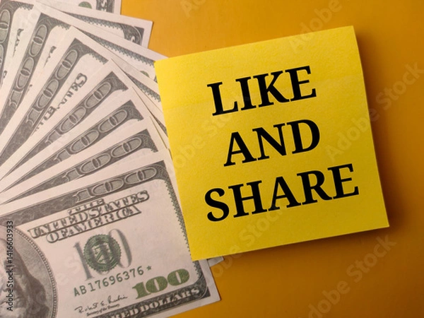 Fototapeta Banknotes and sticky note with the word LIKE AND SHARE on a yellow background