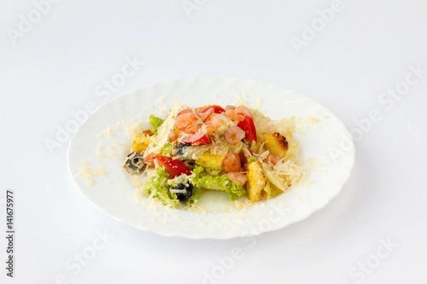 Fototapeta Салат с креветками. Креветки, помидор, маслины, листья салата посыпаны тертым твердым сыром