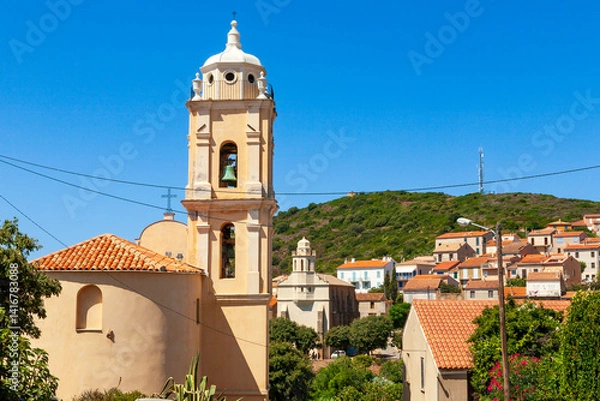 Fototapeta Latin church, in Cargèse, Corsica, France. Typical and picturesque hillside village. Hilltop town nestled on the coast above the Mediterranean sea.