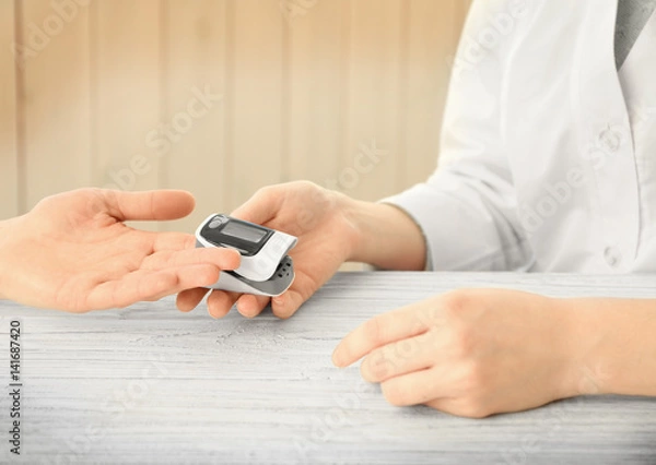 Fototapeta Closeup view of doctor examining woman with heart rate monitor