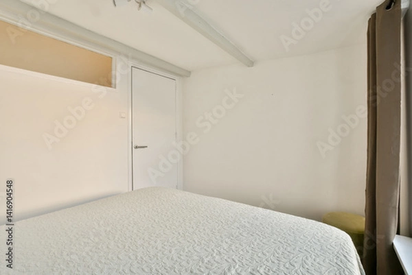 Fototapeta A pristine modern bedroom showcasing a clean design with minimalist decor and ample natural light filtering through the window.