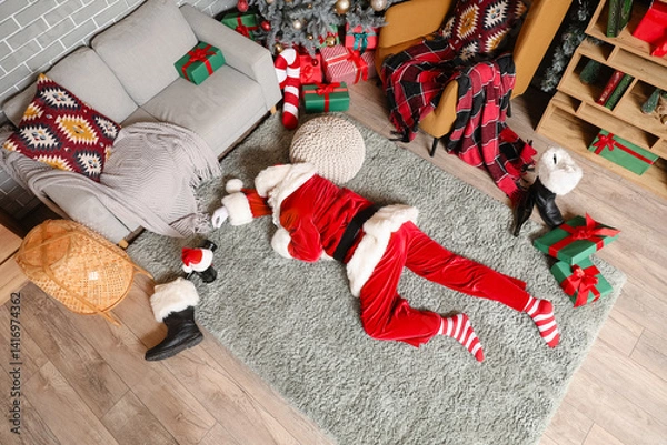Fototapeta Drunk Santa Claus sleeping on carpet after party, top view