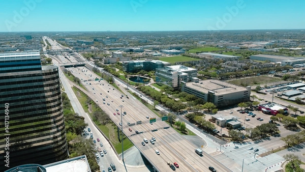 Fototapeta Modern glass office buildings, corporate office headquarters landmark in Westchase business district looking down busy Sam Houston Tollway and Richmond Avenue intersection, highway traffic aerial